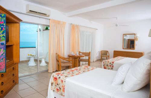 una camera d'albergo con due letti e vista sull'oceano di Tropicana Hotel Puerto Vallarta a Puerto Vallarta