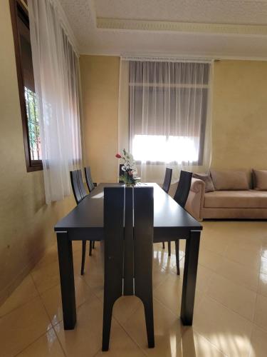 a black dining room table and chairs in a living room at Villa Marrakech Rimass - 6 Chambres Dont 5 Suites Luxe, Piscine Privee & Jardins in Marrakech