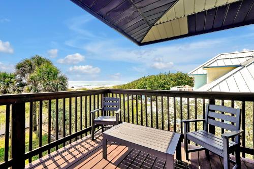 a balcony with two chairs and a bench on it at Villa with Beach Front Views in Cocoa Beach