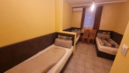 a small room with two beds and a table at Jeweller Hotel in Ruse