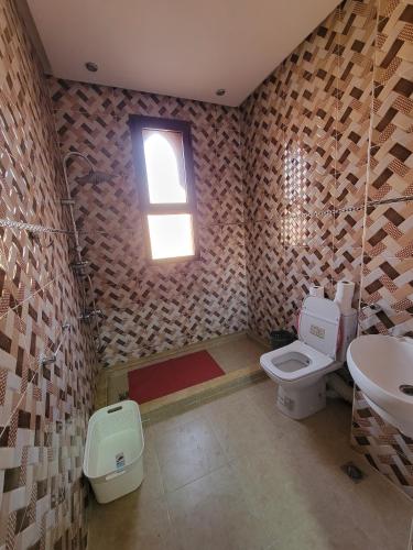 a bathroom with a toilet and a sink and a window at Villa Marrakech Rimass - 6 Chambres Dont 5 Suites Luxe, Piscine Privee & Jardins in Marrakech