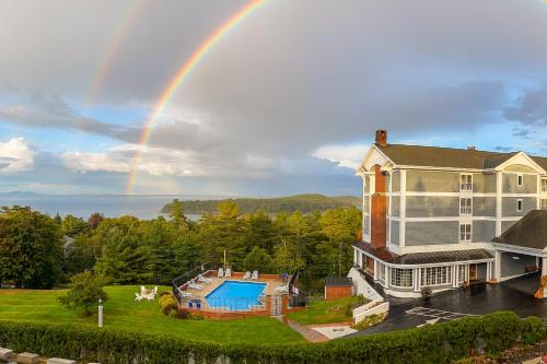 a rainbow over a large house with a pool at Bluenose Inn - Bar Harbor Hotel in Bar Harbor