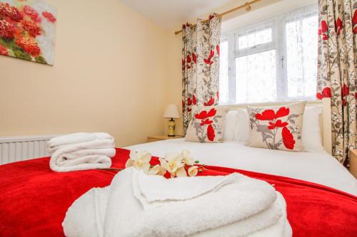a bedroom with a red and white bed with towels on it at Harris Guest Accommodation in Oxford
