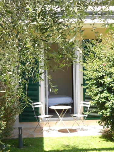 a porch with two chairs and a table and a bed at Albergo Blueline in Tellaro