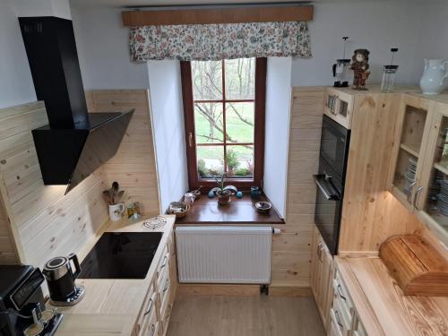 a large kitchen with wooden cabinets and a window at Chata Severka s Wellness in Rokytnice v Orlických Horách