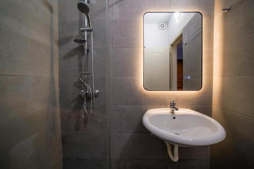ein Badezimmer mit Waschbecken und Spiegel in der Unterkunft Azure blue in Sarandë