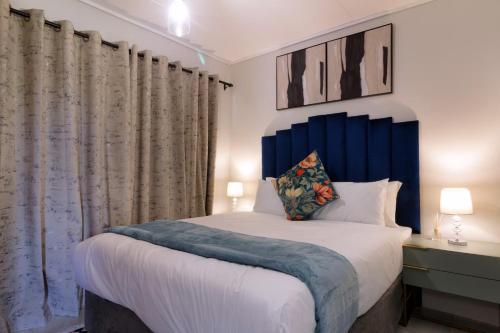 a bed with a blue headboard in a bedroom at Spacious 1Br in Westlands in Nairobi