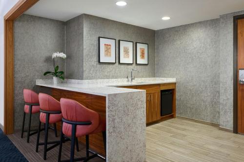 a kitchen with a counter with pink bar stools at JW Marriott Austin in Austin