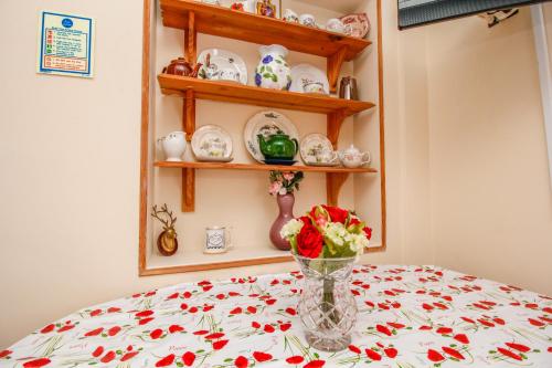 a table with a vase of flowers on a table at Harris Guest Accommodation in Oxford