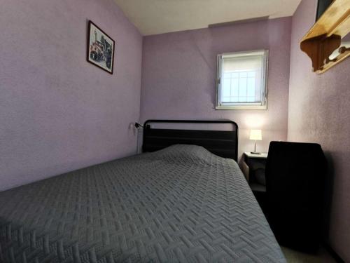 une chambre violette avec un lit et une fenêtre dans l'établissement Résidence Belle Plage - 2 Pièces 4 couchages PORT LEUCATE. Réf: 3BP_36D MAE-8313, à Leucate