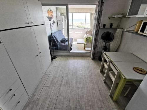 une petite cuisine avec une table et un réfrigérateur dans l'établissement Résidence Les Nefs Des Sables - STUDIO AVEC LOGGIA 5 couchages PORT LEUCATE. Réf: 2NEF_21K3 MAE-8323, à Leucate