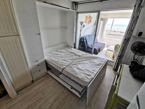 une petite chambre avec un lit et un miroir dans l'établissement Résidence Les Nefs Des Sables - STUDIO AVEC LOGGIA 5 couchages PORT LEUCATE. Réf: 2NEF_21K3 MAE-8323, à Leucate