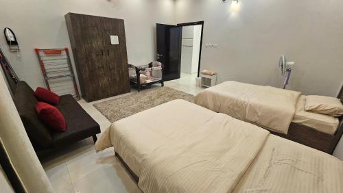 a hospital room with two beds and a chair at شقق سكنية مفروشة بالباحة 1 in Al Jith