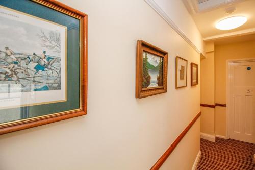 a hallway with paintings on the wall at Harris Guest Accommodation in Oxford