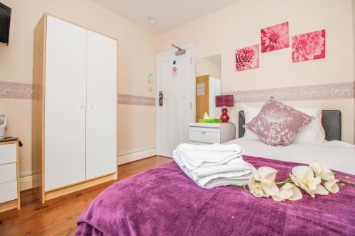 a bedroom with a purple bed with flowers on it at Harris Guest Accommodation in Oxford