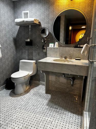 a bathroom with a toilet and a sink and a mirror at The Manhattan Club in New York