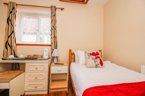 a bedroom with a bed and a dresser and a window at Harris Guest Accommodation in Oxford