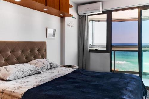 a bedroom with a bed with a view of the ocean at Horizonte Azul - Apartamento Frente Mar no Royal Barra in Rio de Janeiro