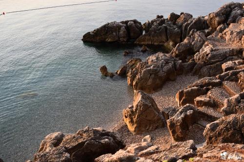 a beach with rocks and the water at Studio apartment Peršić in Mošćenice