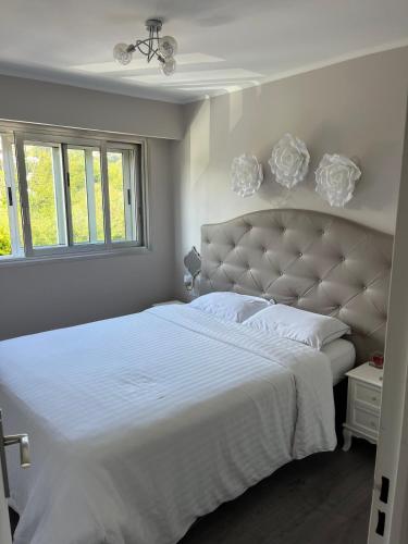 - une chambre blanche avec un grand lit et des draps blancs dans l'établissement Superbe appartement 5min de la plage, à Vallauris