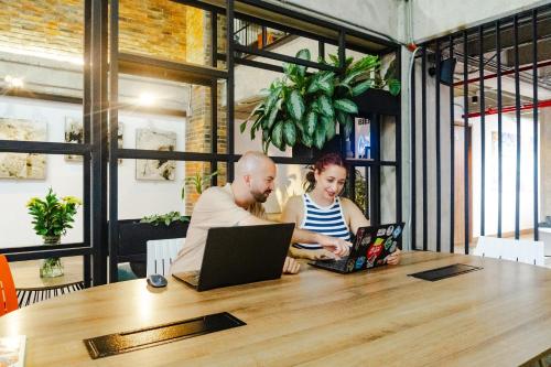 a man and a woman sitting at a table with a laptop at Los Patios Cool Living in Medellín