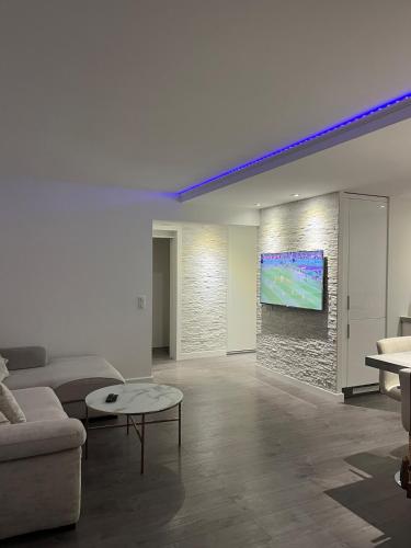 un salon avec un canapé et une télévision sur un mur dans l'établissement Superbe appartement 5min de la plage, à Vallauris