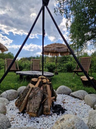 a picnic table with an umbrella on top of rocks at Wyrki - Przestrzeń Rekreacyjna in Ćmińsk