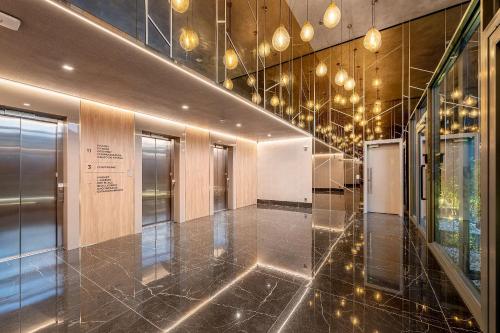 a lobby with a hallway with a staircase with lights at Novíssimo - Skyline Parque Moinhos in Porto Alegre