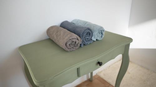 une armoire verte avec des serviettes dessus dans l'établissement Maisonnette éco-responsable au bord de l'eau, à Saint-Loup-du-Dorat