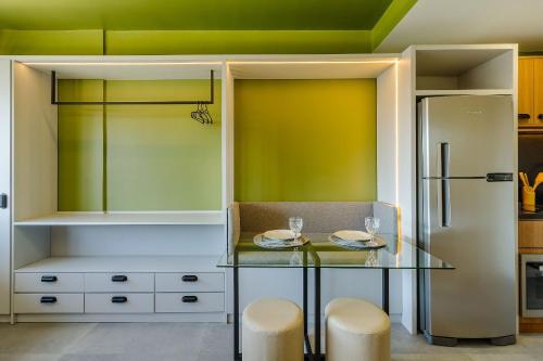 a kitchen with a glass table and a refrigerator at Novíssimo - Skyline Parque Moinhos in Porto Alegre