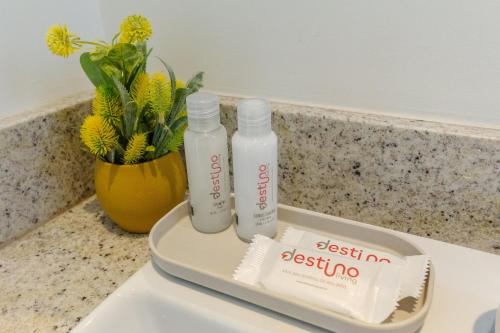 two bottles of sanitizer sitting on top of a sink at Novíssimo - Skyline Parque Moinhos in Porto Alegre