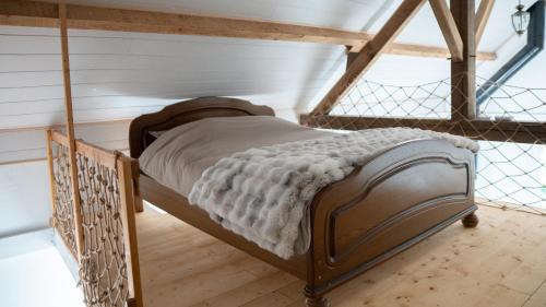 Ce lit se trouve dans un dortoir doté de parquet. dans l'établissement Maisonnette éco-responsable au bord de l'eau, à Saint-Loup-du-Dorat