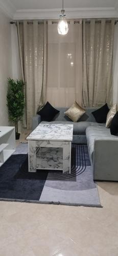 a living room with a couch and a coffee table at Relax nouvelle ville ibn batouta2 in Oulad Akkou