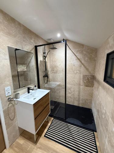 une salle de bain avec une douche avec un lavabo et une douche dans l'établissement Le Chalet belle Vue, à Saint-Martin-de-la-Lieue