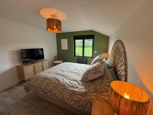 a bedroom with a bed and a television in it at Le Chalet belle Vue in Saint-Martin-de-la-Lieue