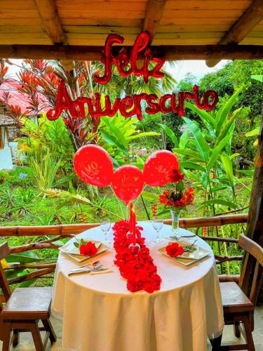 a table with red balloons and a happy anniversary sign at Hotel La Casa de Francois in San Agustín