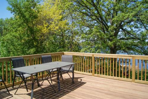 a wooden deck with a table and chairs on it at Waterfront Eagle Lake Home with Yard and Deck in Maple Grove