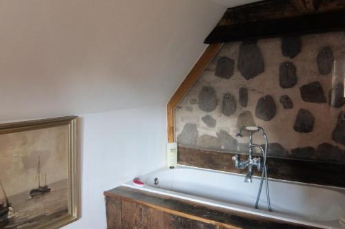 d'une baignoire dans une pièce ornée d'une peinture murale. dans l'établissement Maison D'Augusta, à Mayrinhac-Lentour