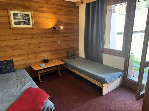 une chambre avec deux lits, une table et une fenêtre dans l'établissement Résidence Lauziere Dessus - La Lauzière Dessus 27 - Studio divisible avec terrasse plein sud MAE-1904, à Valmorel