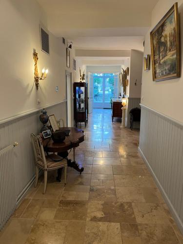- un couloir d'une maison avec une table et des chaises dans l'établissement Maison de maître de 700 m2 en plein cœur de Castelnaudary, à La Celle-sous-Gouzon