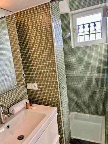 une salle de bain avec un lavabo et une douche dans l'établissement Terrasse, vue mer & montagne, parking & clim, à Nice