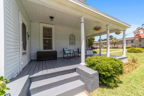 a front porch of a white house with white columns at Martin B- historic district apt with pool in Ocala