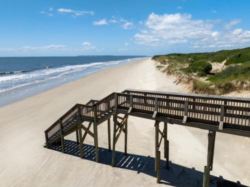a wooden boardwalk on a beach next to the ocean at Hampton Inn & Suites Jekyll Island in Jekyll Island