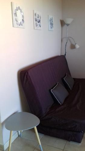 a couch in a room with a table and a lamp at appartement bords de Mer in Santa-Lucia-di-Moriani