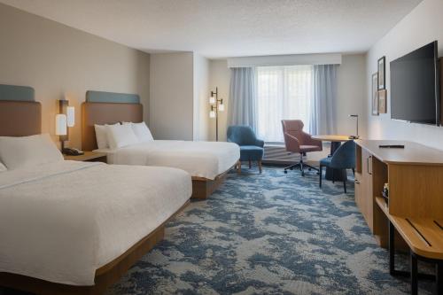 a hotel room with two beds and a desk at Hampton Inn & Suites Jekyll Island in Jekyll Island
