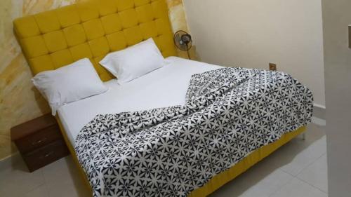 ein Bett mit einer schwarz-weißen Decke drauf in der Unterkunft LOGIS D'HERGUINE - SUITE AGNES - 4 personnes - Piscine - Salle de Mariage in Jaunde