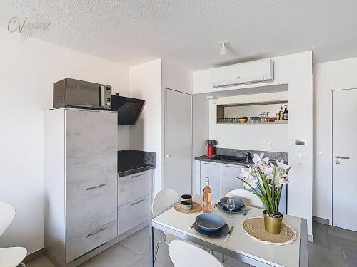 une cuisine avec une table, des chaises et un réfrigérateur dans l'établissement Appartement Asterias à 300m de la plage, à Vias