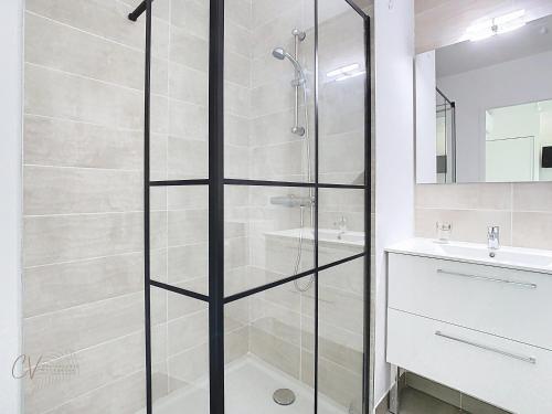 une douche avec une porte vitrée dans une salle de bain dans l'établissement Appartement Asterias à 300m de la plage, à Vias