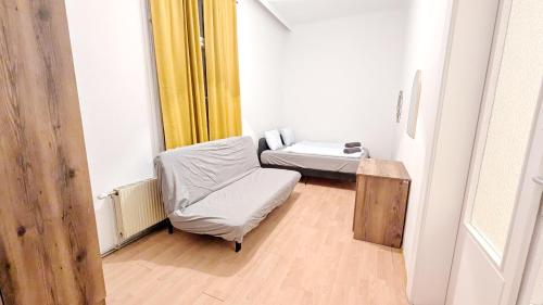 a room with a bed and a chair and a table at Spacious Rooms - 15 Min from Airport & City Center, 5 Min from Vienna Main-Bus Station EZ7 in Vienna