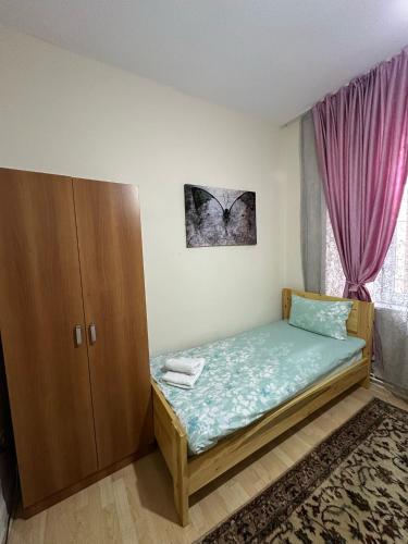 a bedroom with a bed and a cabinet and a window at Hostel Nelly in Istanbul